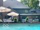 Inviting backyard pool area featuring comfortable seating and manicured landscaping in a serene outdoor setting at 10605 Winterwood, Carmel, IN 46032