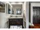 Charming bathroom with dark wood vanity, a decorative mirror, and storage for towels and toiletries at 10605 Winterwood, Carmel, IN 46032