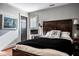 Comfortable bedroom with a decorative 'B' pillow, dark wood floors, and an adjacent window at 10605 Winterwood, Carmel, IN 46032