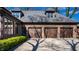 Brick home with three car garage and dormer windows, all beneath a shadow dappled roof at 10605 Winterwood, Carmel, IN 46032