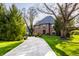 Classic brick home with a circular driveway, mature trees, and well-manicured landscaping at 10605 Winterwood, Carmel, IN 46032