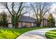 Beautiful brick home featuring mature trees, a paved driveway and lush green lawn at 10605 Winterwood, Carmel, IN 46032