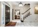 Bright foyer with a marble floor, a grand staircase, and a decorative light fixture at 10605 Winterwood, Carmel, IN 46032