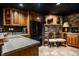 Basement kitchenette displays light countertops, warm wood cabinets, and black appliances at 10605 Winterwood, Carmel, IN 46032