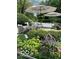 Beautifully landscaped backyard patio with mature trees and plants creating a private outdoor space at 10605 Winterwood, Carmel, IN 46032