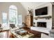 Cozy living room features a white brick fireplace, hardwood floors, and large windows at 10605 Winterwood, Carmel, IN 46032