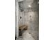 Luxurious walk-in shower features marble tiling, a glass enclosure, and a convenient wooden bench at 10605 Winterwood, Carmel, IN 46032