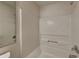 This bright bathroom features a modern shower and bath combination with white fixtures at 10689 Brooks St, Indianapolis, IN 46234