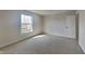 A bright bedroom offers neutral walls and plush carpeting with a large window and white trim at 10689 Brooks St, Indianapolis, IN 46234