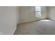 Bright bedroom provides neutral walls and carpeting with a large window and white trim at 10689 Brooks St, Indianapolis, IN 46234