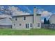 Back exterior view shows a well maintained yard with a spacious patio and neutral siding at 10689 Brooks St, Indianapolis, IN 46234