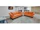 Cozy basement featuring two orange sofas, plank flooring, stone accents, and wet bar at 11347 Whitewater Way, Fishers, IN 46037