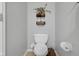 Bathroom featuring a toilet with bidet, decorative wall art, and a basket for extra storage at 11347 Whitewater Way, Fishers, IN 46037