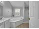 Bathroom with a large tub under a window, a tiled floor, and a separate shower at 11347 Whitewater Way, Fishers, IN 46037
