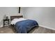 Bedroom featuring gray wood floors and a comfortable bed, illuminated by natural light from a nearby window at 11347 Whitewater Way, Fishers, IN 46037