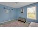 Cozy bedroom featuring light blue walls, a comfortable bench, and natural light from the window at 11347 Whitewater Way, Fishers, IN 46037