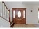Ornate wood front door with decorative glass inserts, complemented by tiled flooring and a nearby staircase at 11347 Whitewater Way, Fishers, IN 46037
