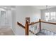 Upper hallway boasting dark wood railing and a pendant light, creating an inviting ambiance at 11347 Whitewater Way, Fishers, IN 46037