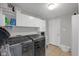 Well-equipped laundry room with tile flooring, white cabinets, and modern black washer and dryer at 11347 Whitewater Way, Fishers, IN 46037