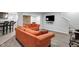Relaxing living room featuring stone accent wall, hard flooring, and comfortable orange couches at 11347 Whitewater Way, Fishers, IN 46037