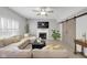 Cozy living room showcasing a fireplace, decorative sliding barn doors and a large sectional sofa at 11347 Whitewater Way, Fishers, IN 46037