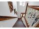 Carpeted stairs with dark wood treads lead up to a bright landing with decorative wall art at 11347 Whitewater Way, Fishers, IN 46037