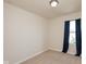 This is a cozy bedroom with neutral walls, carpet flooring, and a window with blue curtains at 11617 Tahoe Way, Indianapolis, IN 46235