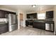 Modern kitchen featuring stainless steel appliances, dark cabinets, and a gray backsplash at 11617 Tahoe Way, Indianapolis, IN 46235