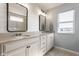 Bright bathroom with double sinks, white cabinetry, light countertops, and a shiplap accent wall at 11880 Whisper Ridge Dr, Noblesville, IN 46060