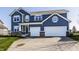 Charming two-story home with a two-car garage, beautiful blue siding and a well-manicured front lawn at 11880 Whisper Ridge Dr, Noblesville, IN 46060
