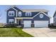 Charming two-story home with a two-car garage, beautiful blue siding and a well-manicured front lawn at 11880 Whisper Ridge Dr, Noblesville, IN 46060