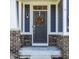 Close up of front door with wreath, classic lantern and stylish brick accents on a charming exterior at 11880 Whisper Ridge Dr, Noblesville, IN 46060