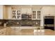 Close-up of a kitchen featuring a center island, stainless steel microwave and range hood, and white cabinetry at 11880 Whisper Ridge Dr, Noblesville, IN 46060