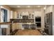 Bright and airy kitchen features stainless steel appliances, white cabinetry, and a center island with bar stool seating at 11880 Whisper Ridge Dr, Noblesville, IN 46060