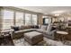 Spacious living room featuring a plush sectional sofa, large windows, and open layout to the kitchen at 11880 Whisper Ridge Dr, Noblesville, IN 46060