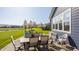Paved backyard patio features outdoor dining furniture, and lush greenery at 11880 Whisper Ridge Dr, Noblesville, IN 46060