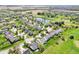 An aerial view features a well-maintained residential area with manicured lawns, mature trees, and a serene pond at 12088 Everwood Cir, Noblesville, IN 46060