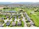 An aerial view features a well-maintained residential area with manicured lawns, mature trees, and a serene pond at 12088 Everwood Cir, Noblesville, IN 46060