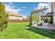 Lush backyard with a well-maintained lawn, pergola with swing, and wooden privacy fence at 12088 Everwood Cir, Noblesville, IN 46060