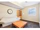 Bright basement area featuring a comfortable couch, bookshelf, large clock and a window with natural light at 12088 Everwood Cir, Noblesville, IN 46060