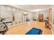 Large basement area with wood laminate flooring that features a mirror, workout machine, and desk at 12088 Everwood Cir, Noblesville, IN 46060
