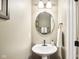 Neat half bathroom featuring a pedestal sink, round mirror, and classic fixtures at 12088 Everwood Cir, Noblesville, IN 46060