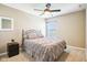 A serene bedroom with a dark ceiling fan, carpet, a nightstand, and an iron bed with a gray comforter at 12088 Everwood Cir, Noblesville, IN 46060
