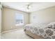 Neutral bedroom with a ceiling fan, window with blinds, and comfortable bed with gray patterned comforter at 12088 Everwood Cir, Noblesville, IN 46060