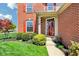 Close-up of a home's brick facade, showcasing a decorative front door and lush landscaping at 12088 Everwood Cir, Noblesville, IN 46060