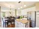 Open kitchen showcases an island with seating, stainless steel refrigerator, and seamless flow to living areas at 12088 Everwood Cir, Noblesville, IN 46060
