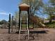 Community playground featuring a slide and climbing structure with mature trees and a mulch ground covering at 12088 Everwood Cir, Noblesville, IN 46060
