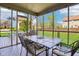 Screened-in porch with a dining table and chairs overlooking a well-maintained backyard and patio area at 12088 Everwood Cir, Noblesville, IN 46060