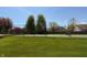 Community tennis court with green turf, a net, and surrounded by a chain-link fence, with trees nearby at 12088 Everwood Cir, Noblesville, IN 46060