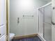 Bathroom featuring a glass-enclosed shower, toilet, handrails, and neutral wall color at 12249 E Harvest Glen Dr, Cumberland, IN 46229